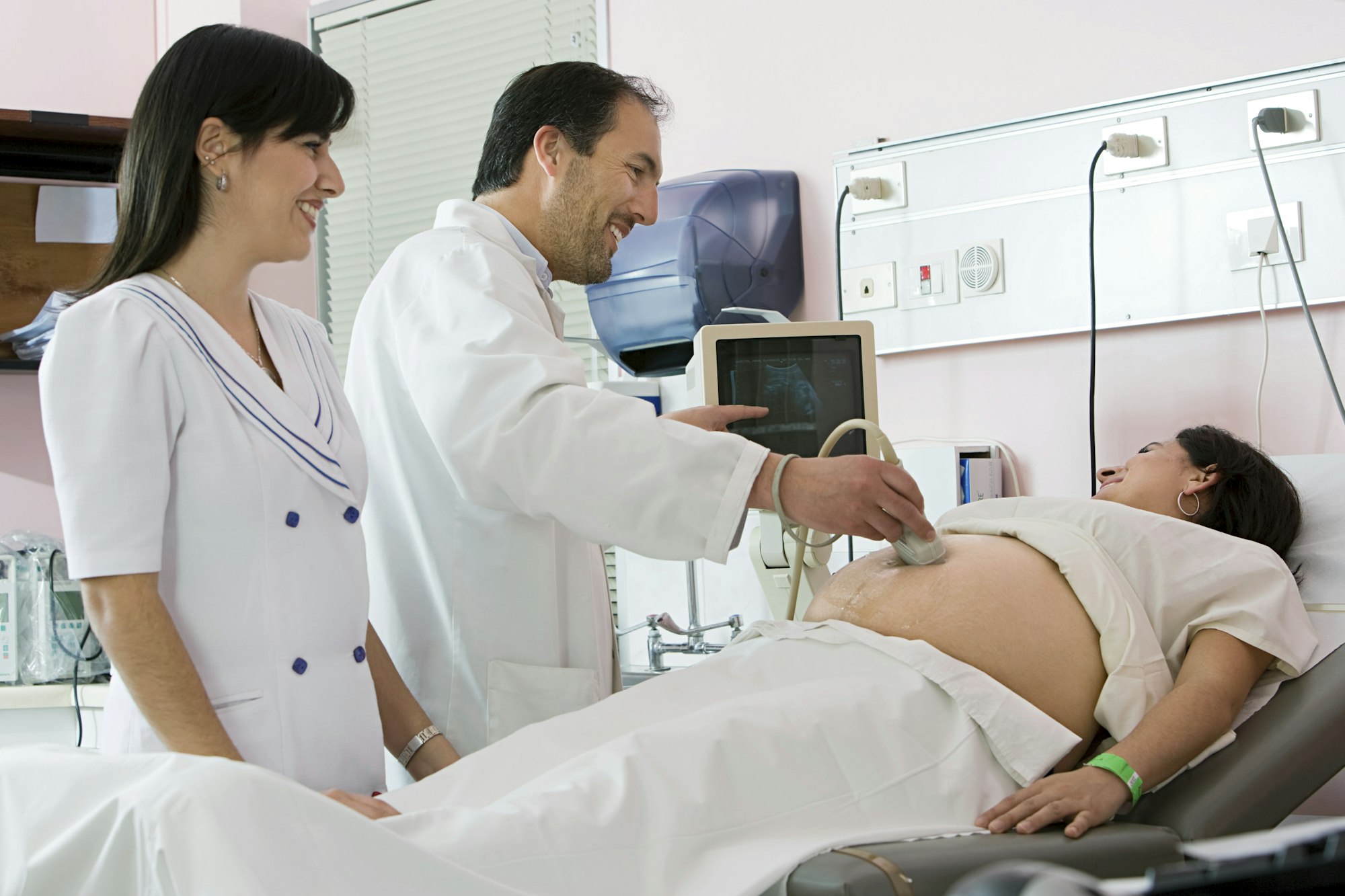 Expectant mother getting an ultrasound with healthcare professionals