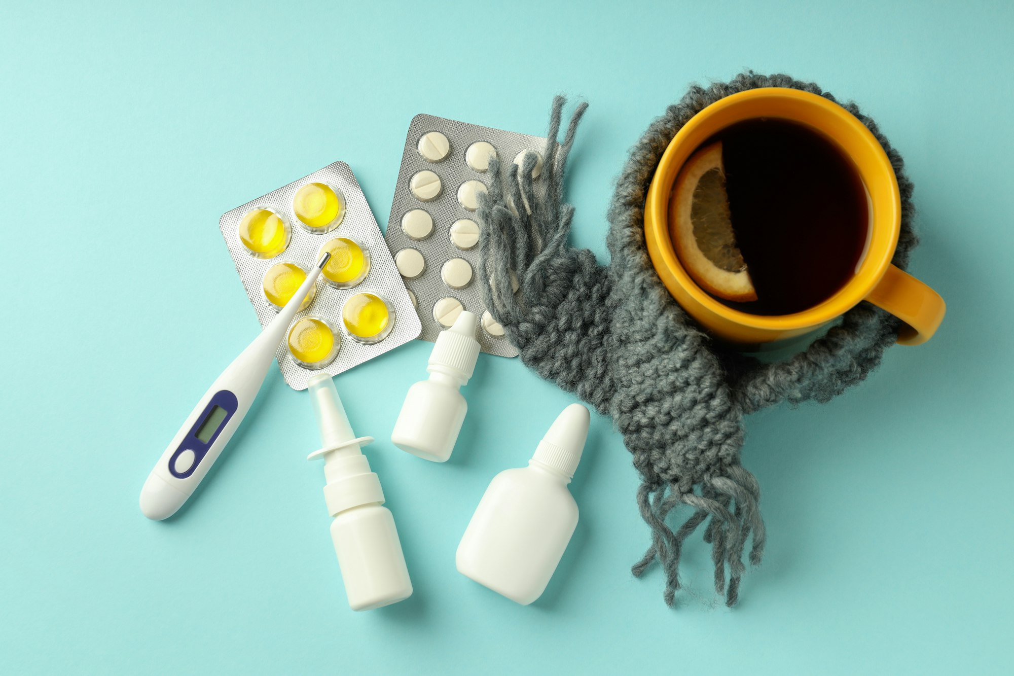 Flu treatment accessories on blue background, top view
